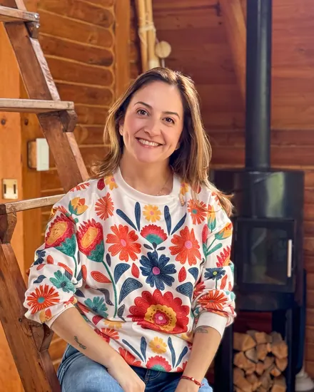 Andrea Toro en Casa Libélula, junto a la escalera de madera y la chimenea